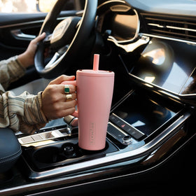 Tumbler shown in a standard cup holder for travel-friendly design.