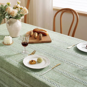 Chassic sage green dining ambience with tablecloth; calm, spring-ready mood.