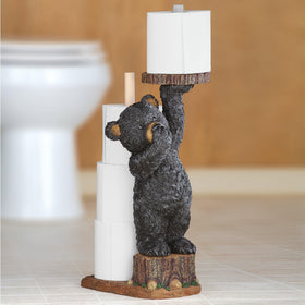 Bear cub on tree stump with spare rolls for quick refills.