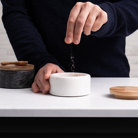 Cork & Mill acacia lid salt keeper shown with spoon, preserves flavor and prevents clumping.