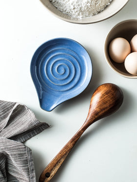 Cormomu heat-resistant ceramic spoon rest protects surfaces during use.