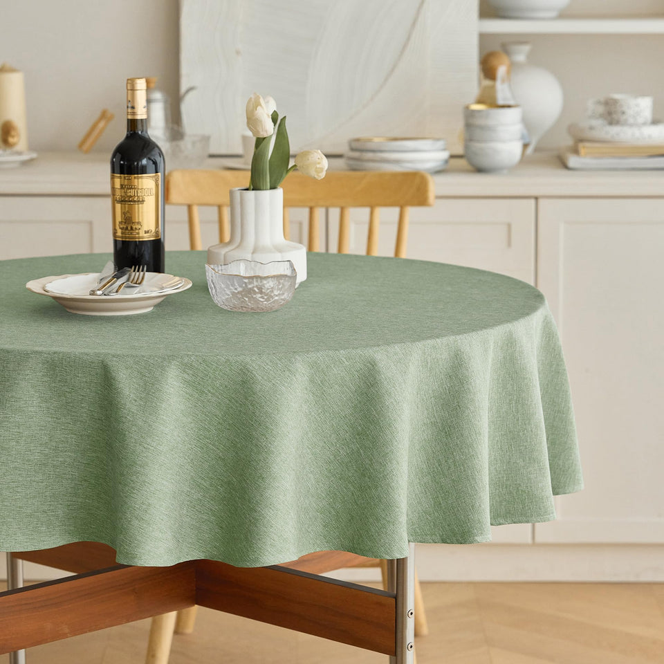 Decorelia faux linen round tablecloth in sage green for 4 to 6 seats on a 70 inch table