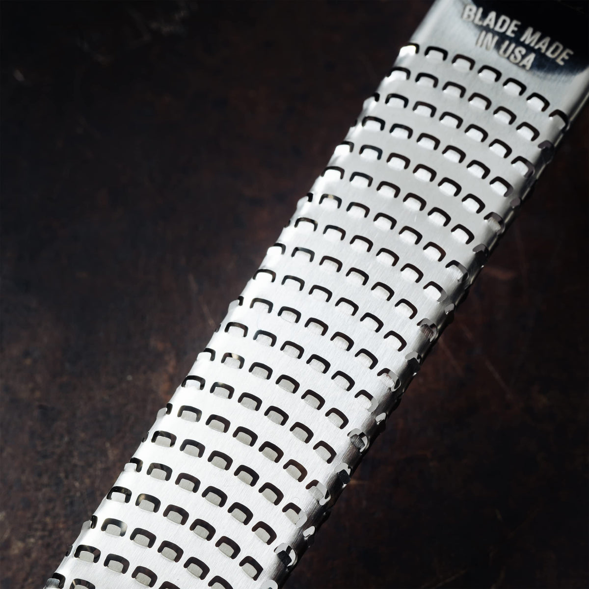 Microplane dusty rose zester grating ginger to create fragrant pastes.