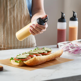 MIGHTY STRONG bottle in use during grilling or dressing preparation for controlled pours.