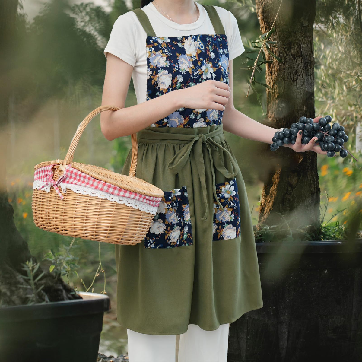 Pinknoke Vintage Pinafore Apron in olive green worn at the side for comfort.