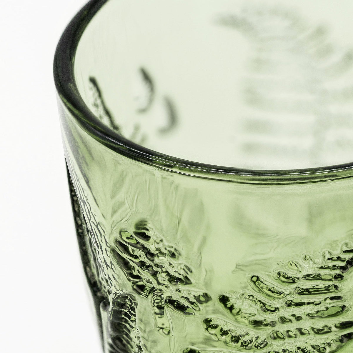 Hand-pressed fern detail on QELVIO glass showcases artisanal craft.