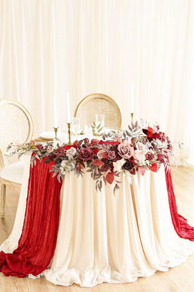 Seveups red cheesecloth table runner draped to create boho rustic charm in events.