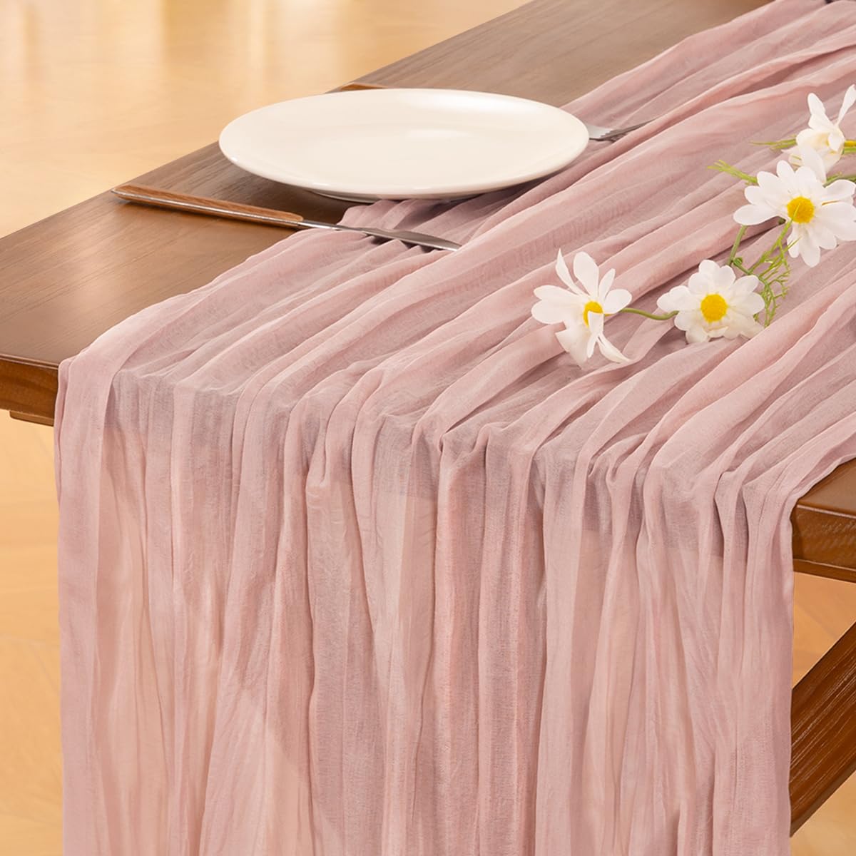 Socomi pink cheesecloth table runner on a wedding table for romantic ambience.
