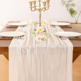 Socomi ivory cheesecloth runner adds rustic texture to a dining table.