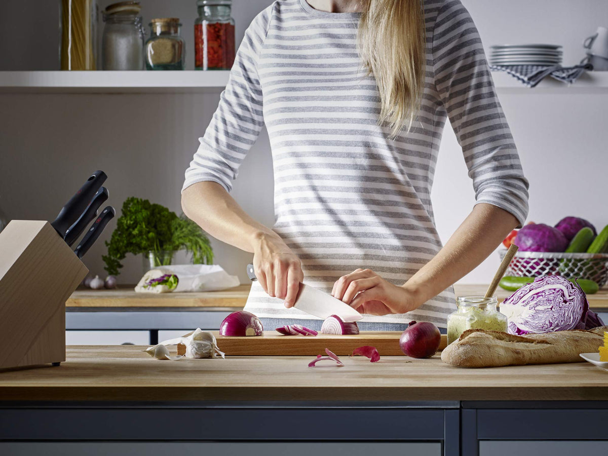 WÜSTHOF Gourmet utility knife used for mincing herbs and vegetables.
